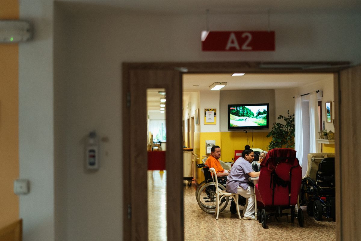 Hallway of a nursing home with residents gathered at the end of the corridor
