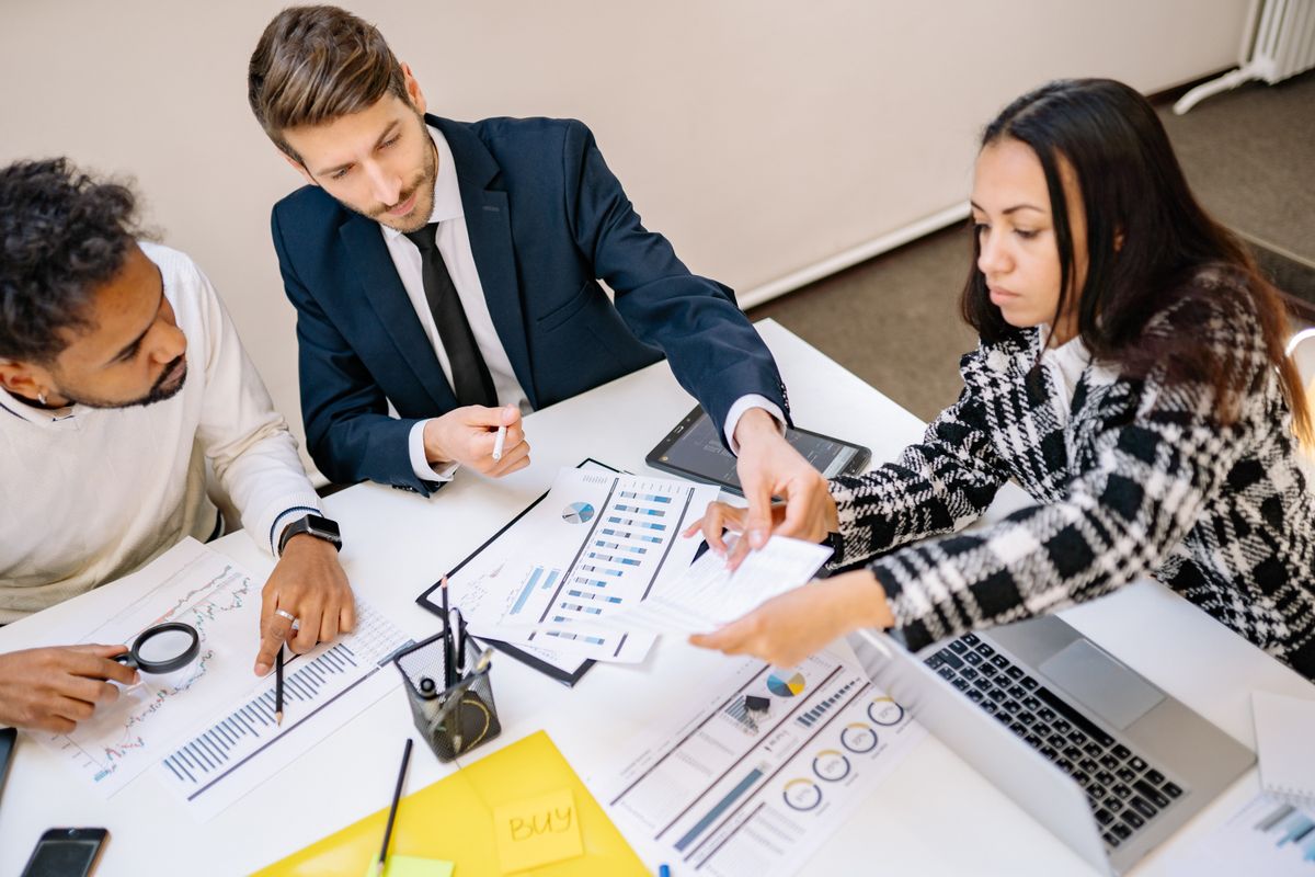 Leadership team reviewing printed reports and charts at a conference table